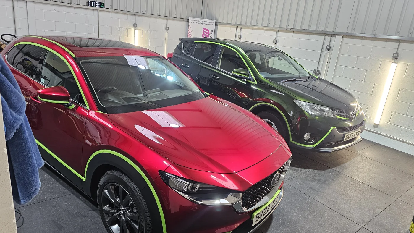 Red and dark green cars inside the detailing unit
