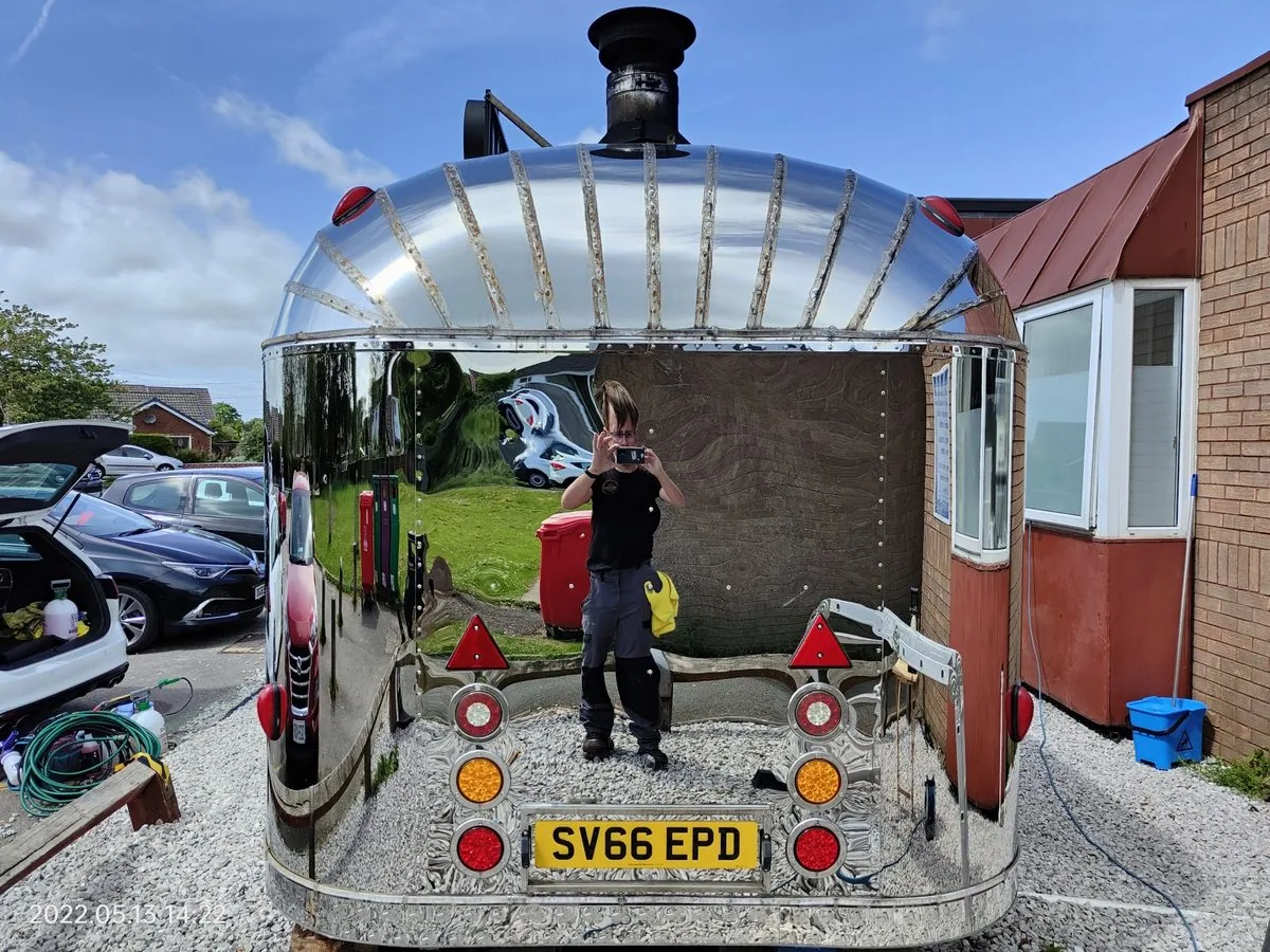 A polished aluminium Airstream pizza van outside the unit